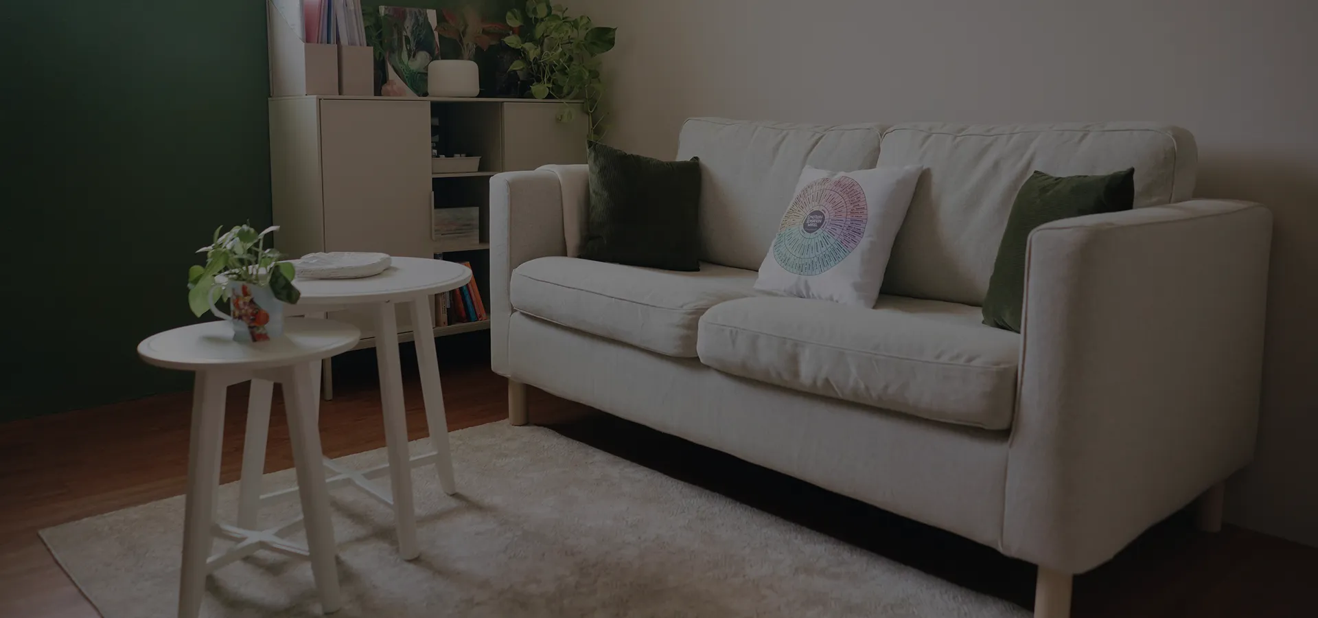 A calm therapy room with a sofa, cushions and a small side table