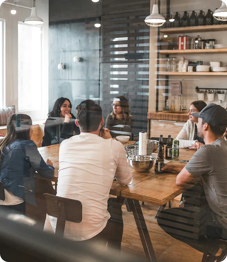 A team talking together around a long table in a bright café